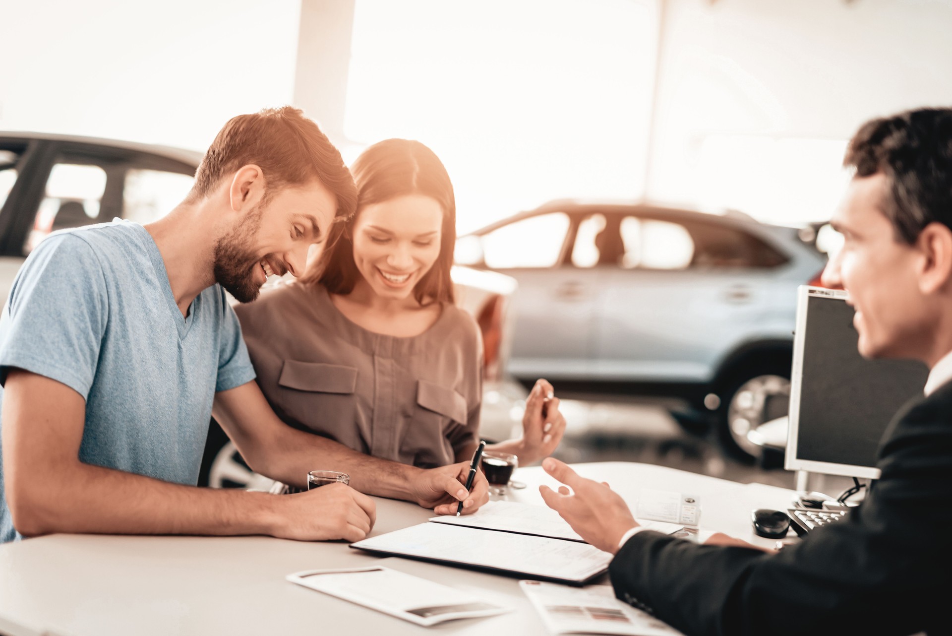 Young Family Are Signing A Contract To Buy A Car.